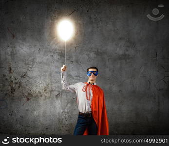 Brave superhero. Young confident superman in mask and cape