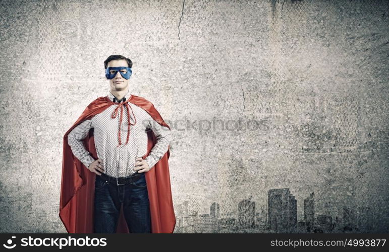 Brave superhero. Young confident superman in mask and cape