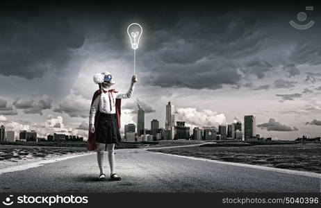 Brave superkid. Cute girl of school age in superhero costume with balloon in hand