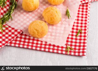 Brazilian cheese buns over red towel on wooden table.