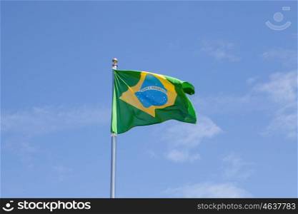Brazilian flag waving in the mast with blue sky background