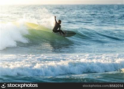Brazilian surfer in action in the waves of the Atlantic coast of Portugal. On a sunny afternoon at Furadouro beach, Ovar - Portugal.