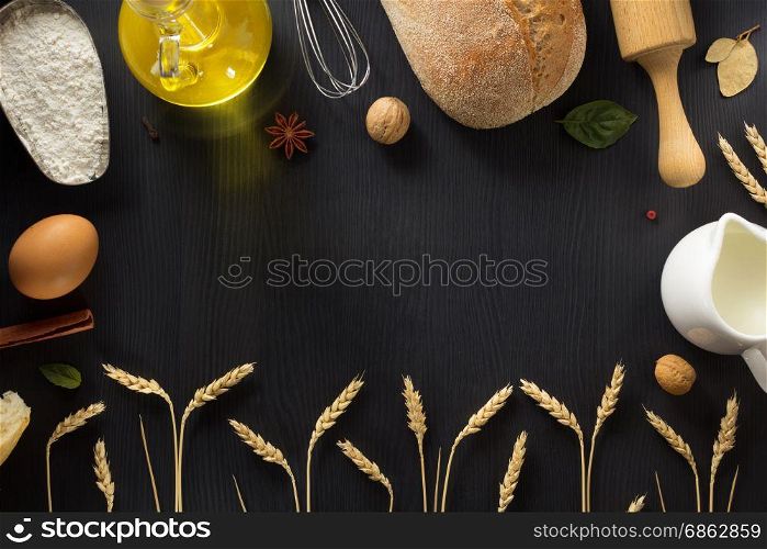bread and ears of wheat on wood background