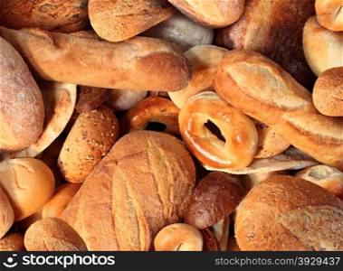 Bread background staple food concept with a group of baked goods from a bakery or home cooking made from whole wheat and grains with breads as pumpernickel pita focaccia bagel made from dough.