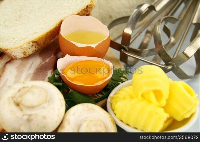 Bread, bacon, eggs, butter with toast ready to be cooked for an omelette.