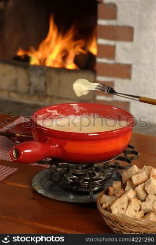 Bread being dipped into the melted cheese in the fondue bowl.