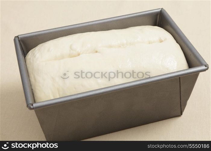 Bread dough in a baking tin after rising, when it is ready for the oven
