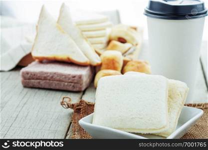 Bread in dish and coffee cup on table.