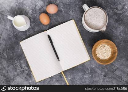 bread ingredients with book pen concrete backdrop
