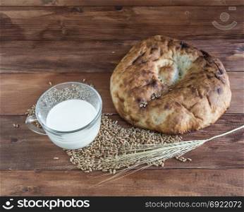 Bread, milk and wheat on a wooden background