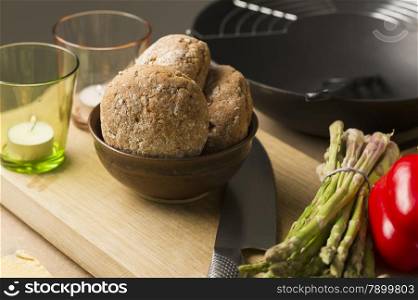 Bread on Bowl on Board with Glasses and Knife. Close up Brown Bread on Bowl on Top of Wooden Board with Candles on Glasses and Cutting Knife