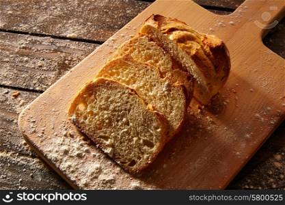 Bread sliced loaf on wooden board in rustic wood table