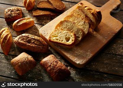 Bread varied loafs sliced on wood board in rustic wood table
