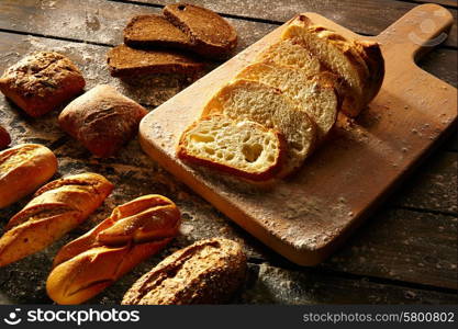 Bread varied loafs sliced on wood board in rustic wood table
