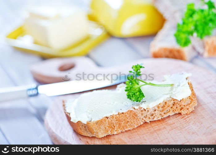 bread with butter on board and on a table