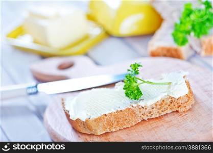 bread with butter on board and on a table