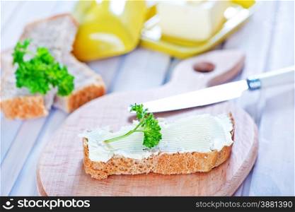 bread with butter on board and on a table