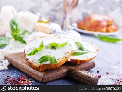 bread with cheese on wooden board and on a table