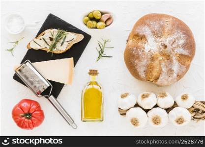 bread with cheese rosemary oil tomato olive with bunch garlic bulbs o white backdrop