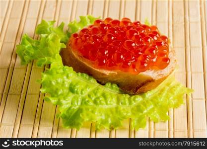 bread with red caviar on a bamboo napkin