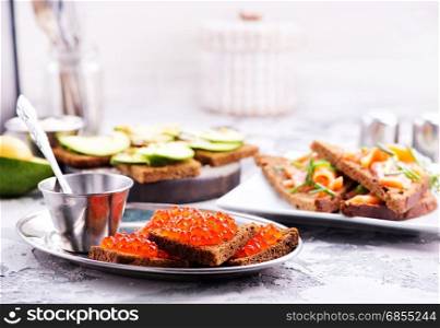 bread with red salmon caviar on a table