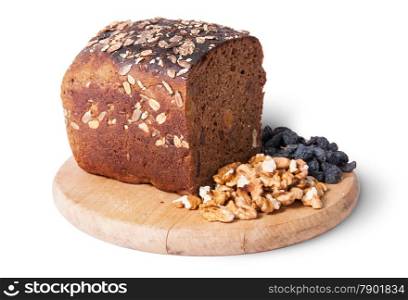 Bread with seeds on wooden board with raisins and nuts isolated on white background