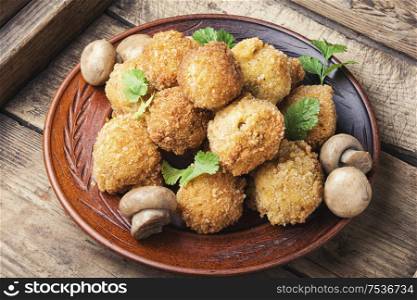 Breaded mushrooms or deep-fried mushrooms in a old wooden tray. Mushrooms in breadcrumbs.