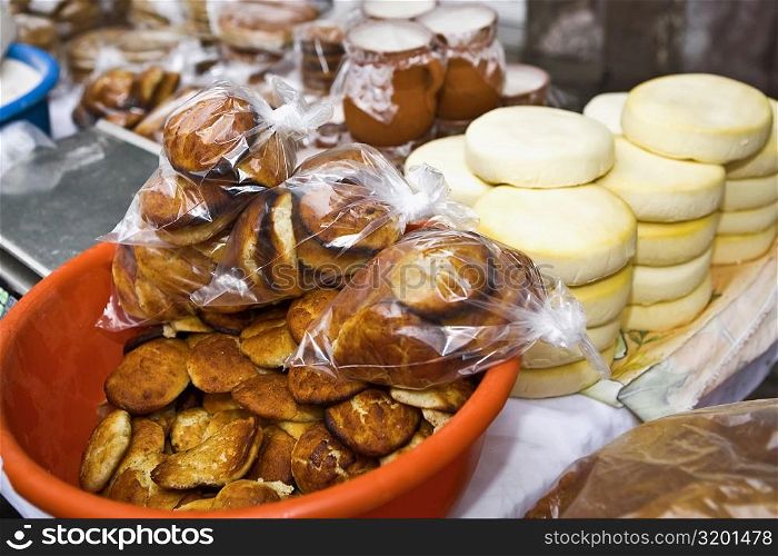 Breads and stacks of cheese at a market stall, Zacatecas State, Mexico