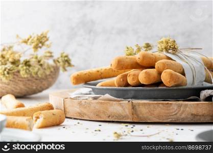 Breadsticks grissini. Bread sticks with sesame seeds, oregano and olive oil and balsamic vinegar on kitchen countertop.