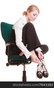 Break from work. Tired businesswoman with leg pain. Young woman massaging her feet on chair isolated on white.