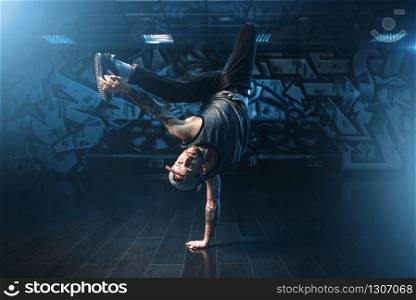 Breakdance action, dancer posing in dance studio. Modern urban dancing style