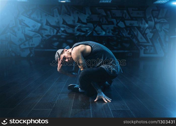 Breakdance performer posing in dance studio. Modern urban dancing style