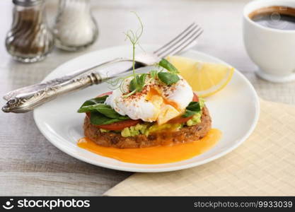  Breakfast. Best Eggs Benedict on a slice of toasted cereal bread with guacamole and spinach