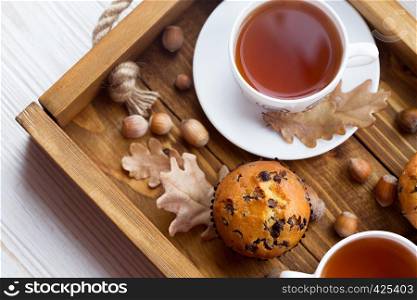breakfast - cake and cup of tea on a wooden tray