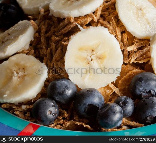 Breakfast cereal with bananas blueberries and bran flakes in bowl