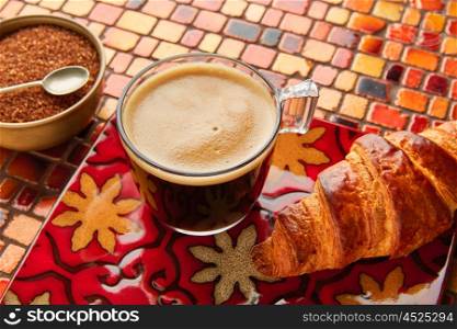 Breakfast coffee and croissant with brown sugar on red brown tiles table