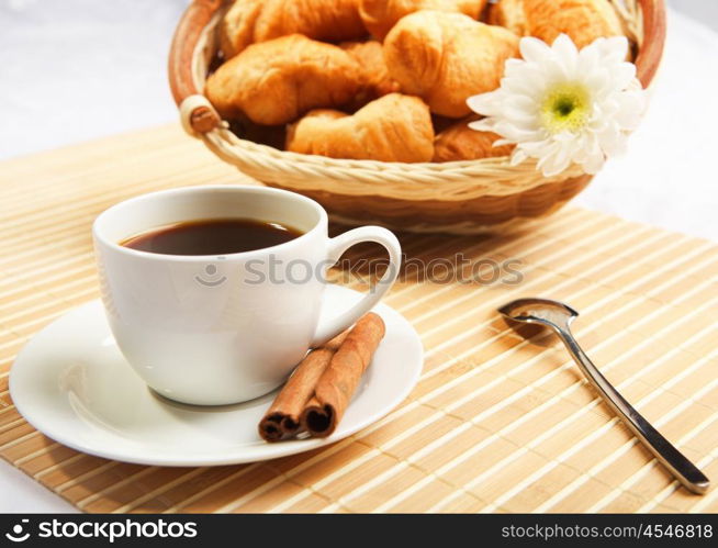 Breakfast coffee and croissants on a table on a light background.