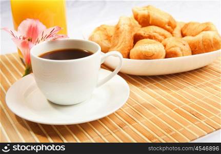 Breakfast coffee and croissants on a table on a light background.