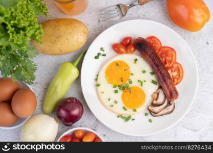 Breakfast consisting of bread, fried eggs, tomatoes, Chinese sausage and mushrooms