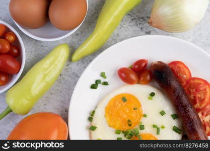 Breakfast consisting of bread, fried eggs, tomatoes, Chinese sausage and mushrooms