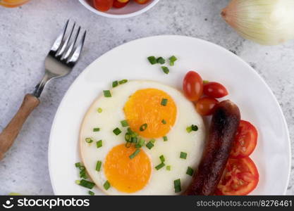 Breakfast consisting of bread, fried eggs, tomatoes, Chinese sausage and mushrooms