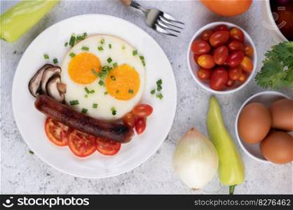 Breakfast consisting of bread, fried eggs, tomatoes, Chinese sausage and mushrooms