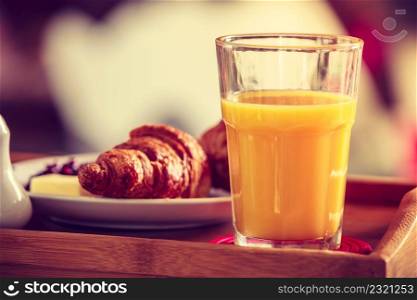 Breakfast consisting of croissants and orange juice. Balanced diet, food, health concept.. Breakfast on little table, orange juice croissant