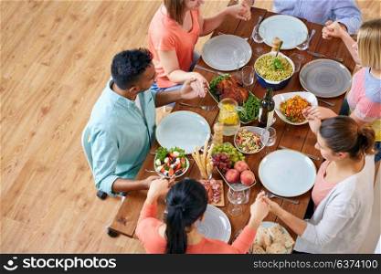 breakfast, family and religious concept - group of people with food sitting at table and praying before meal. group of people at table praying before meal