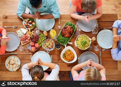 breakfast, family and religious concept - group of people with food sitting at table and praying before meal. group of people at table praying before meal