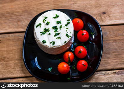 Breakfast food, cheese and cherry tomatoes on dish, on a rustic wooden plank board table background.. Breakfast food, cheese and cherry tomatoes on dish, on a rustic wooden plank board table background.