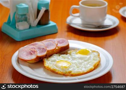 Breakfast. Fried eggs, a sandwich and tea