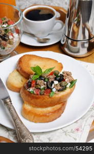 Breakfast from fried toast with chopped tuna with egg, cubes of tomatoes and olive slices, capers with a cup of coffee, a coffee pot on a tray