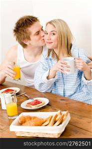 Breakfast happy couple enjoy romantic kiss in kitchen