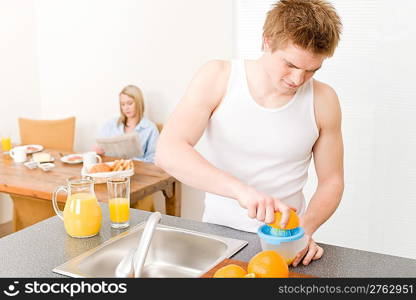 Breakfast happy couple make orange juice in morning kitchen